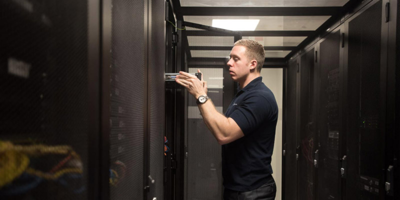 A member of SC racking up a server in a cabinet