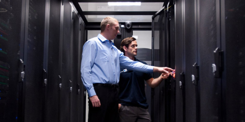 Two SC members checking a server cabinet