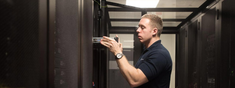 An engineer racking up a server