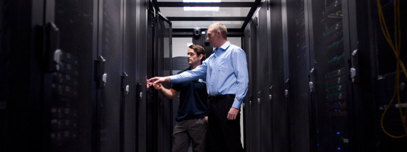 2 engineers looking into a server rack in a data centre